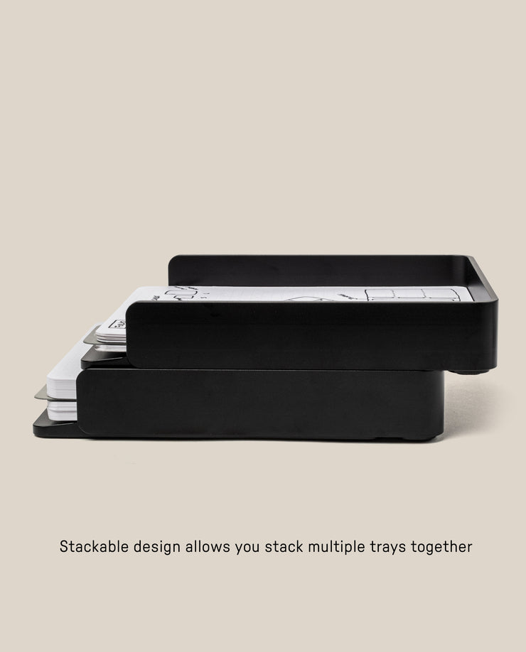 A side view of two Analog Capture Kit - 2 Large (Black Aluminum) trays stacked together holding papers, showcasing their stackable design. Text below: Stackable design lets you combine multiple trays for efficient organization.