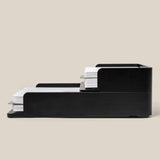 Two black aluminum Analog Capture Kit trays (Small & Large) are stacked, each holding paper or Dot Grid Cards. Their modern, minimalist design features a stackable system for combining multiple trays. Text: Stackable design lets you stack multiple trays together.