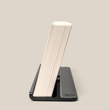 The Complete Analog Collection (Black Aluminum) holds a thick stack of paper or cards upright in a sleek black organizer against a plain beige background.