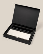 The Analog Weekly Planning Kit (Black Aluminum) features a sleek silver aluminum card stand with multiple rectangular buttons, nestled in a black foam insert inside an open black box set against a beige background.
