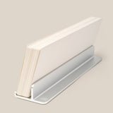 A stack of white Analog Weekly Planning Kit cards is held upright in a sleek silver aluminum stand against a beige background.