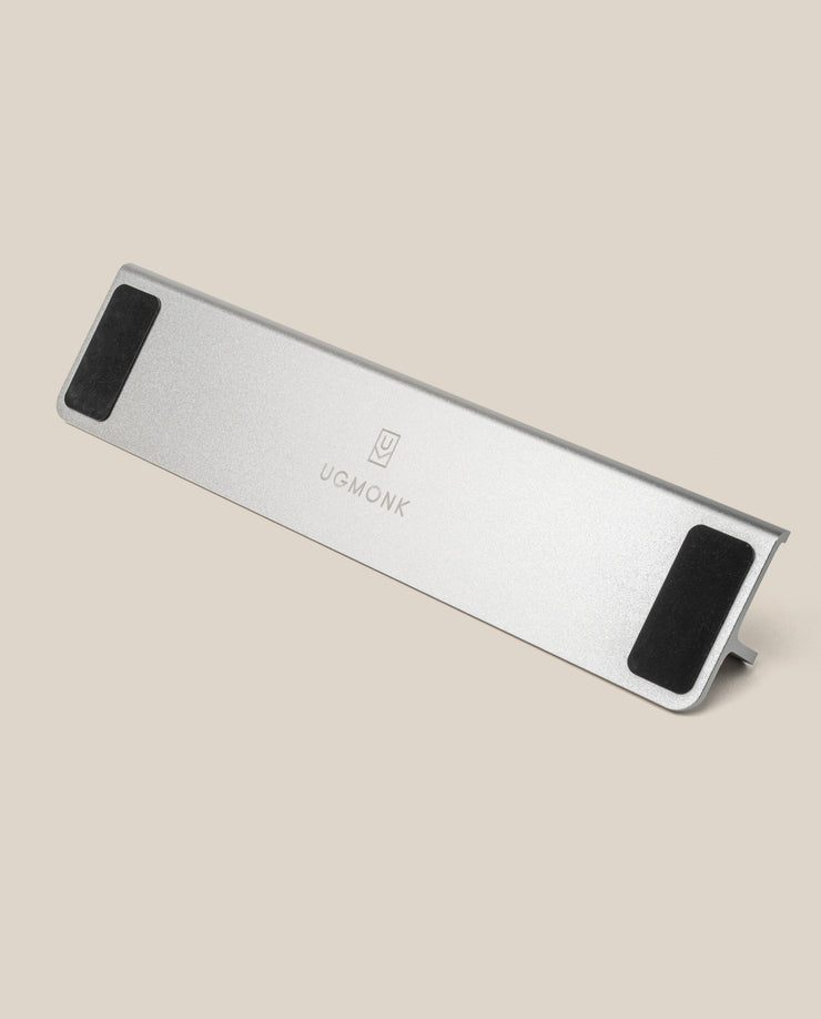A silver Aluminum Card Stand with black non-slip pads and a central Ugmonk logo is displayed on a plain beige background. Complements your Analog Weekly Planning Kit (Silver Aluminum) perfectly for stylish organization.