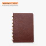 The Warehouse Item - Discbound Heirloom Journal (Brown/Brass), made of full grain leather, is shown with visible creases on the cover. A label reads WAREHOUSE SALE – 50% OFF due to small cosmetic imperfections.