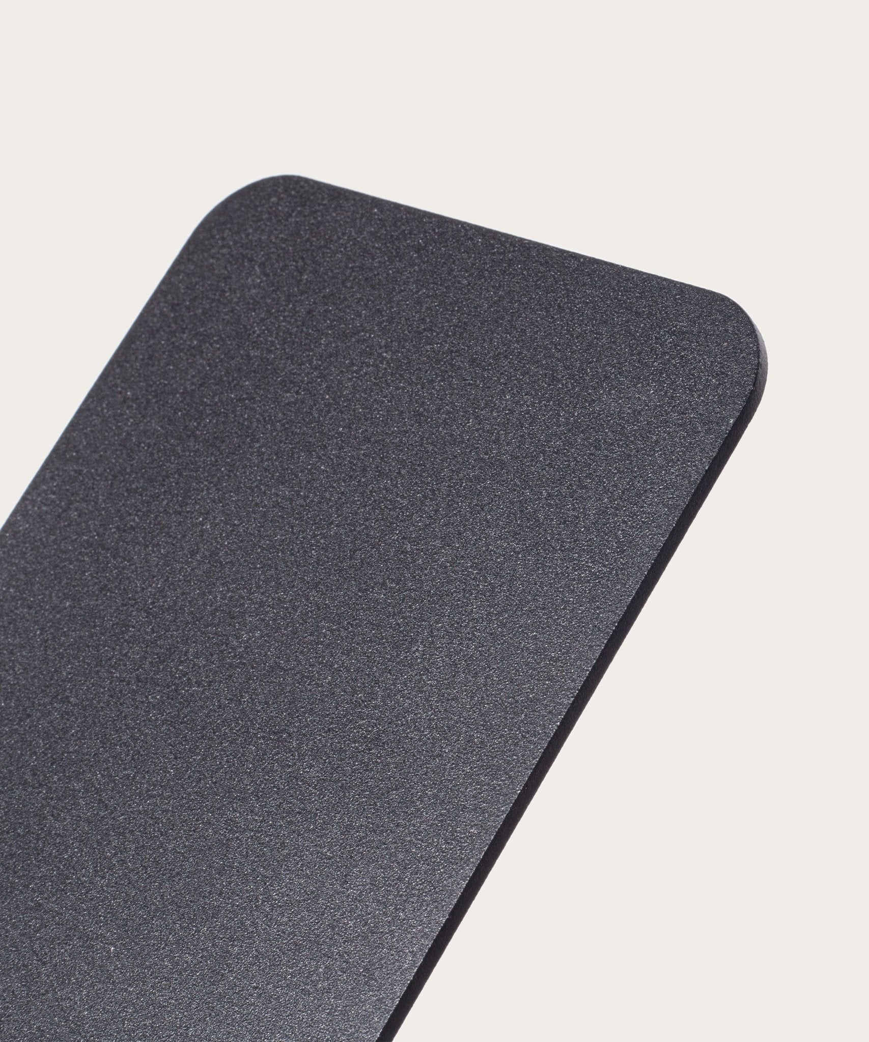 A close-up of the Gather 1x4 Base Plate (Black), a rectangular, matte black steel panel with a textured powder-coated finish and rounded corners, shown against a plain, light background.