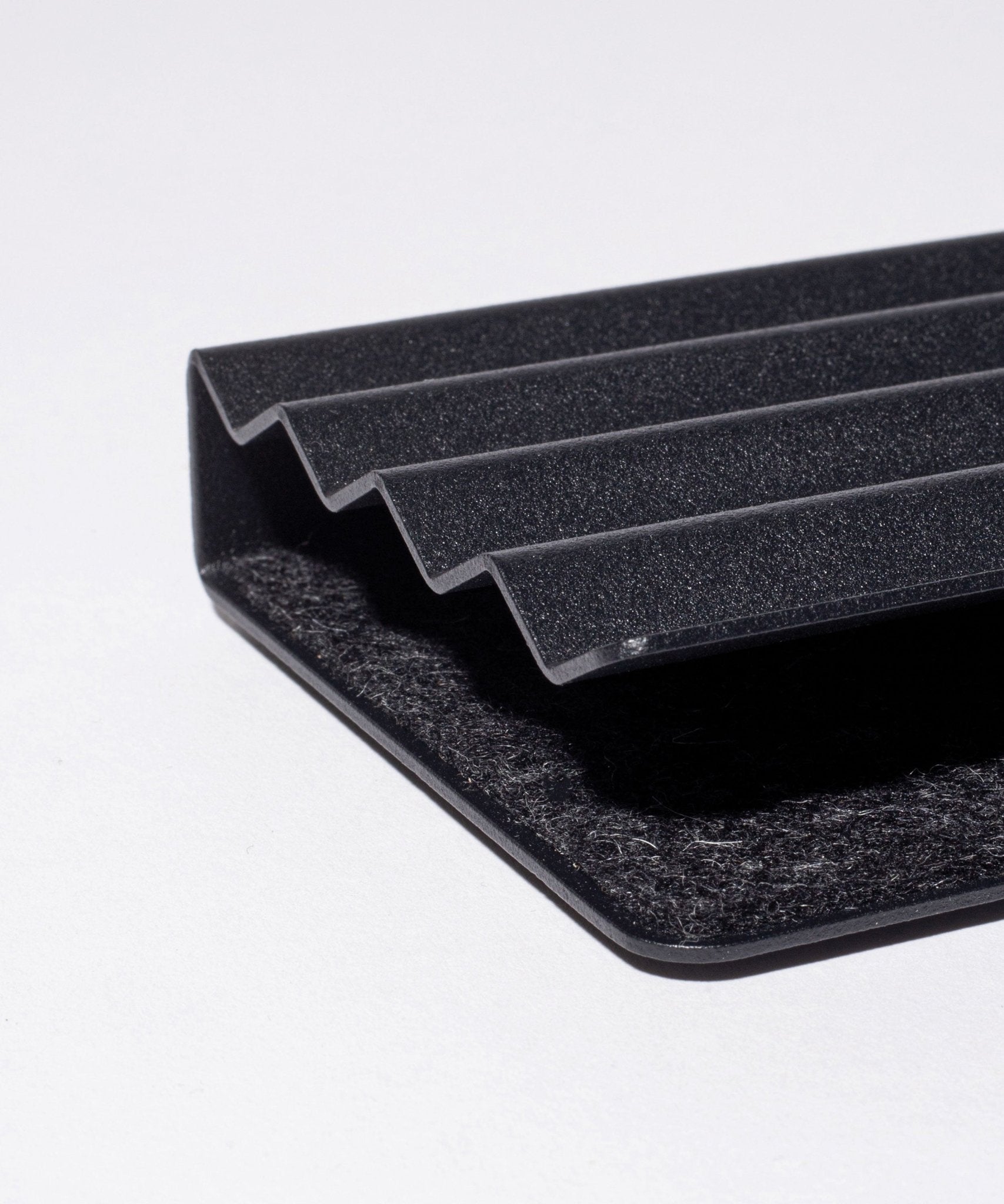Close-up of the Gather Zigzag Tray (2x1 - Black) with four raised ridges and a wool felt-lined interior, showcasing its black textured surface and modern, minimalist design on a white background.