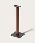 The Gather Headphone Stand (1x1 - Black/Walnut) features a solid walnut vertical column, a black powder coated steel base, and a curved top to hold headphones, all set against a plain light background.