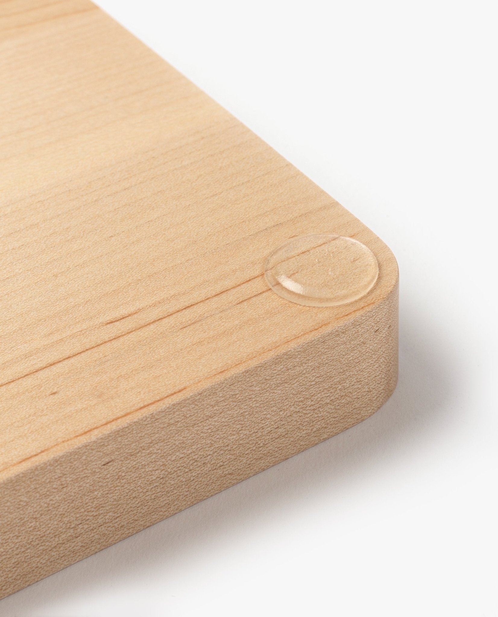 A close-up of the Valet Tray Bundle (Maple - Set of 3) handcrafted in Pennsylvania shows smooth, rounded corners and a single water droplet that highlights the maple wood’s natural texture and refined finish.